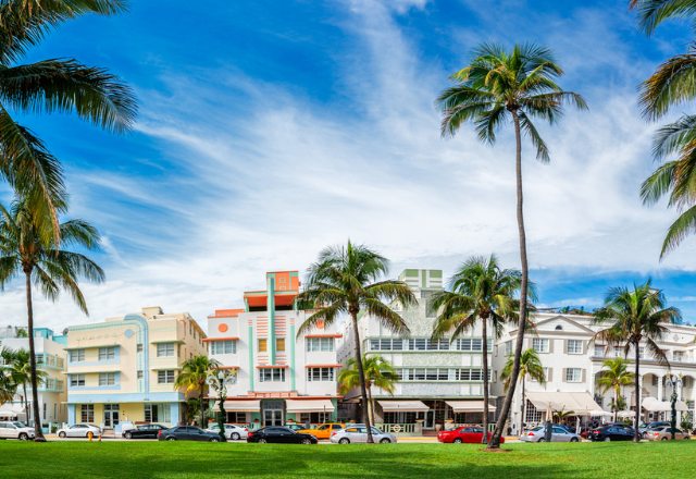 Colorful Miami South Beach buildings with palm trees and green grass