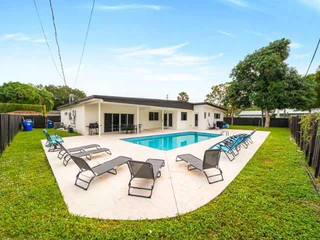 Quaint coastal white bungalow Miami vacation rental with pool and sun loungers
