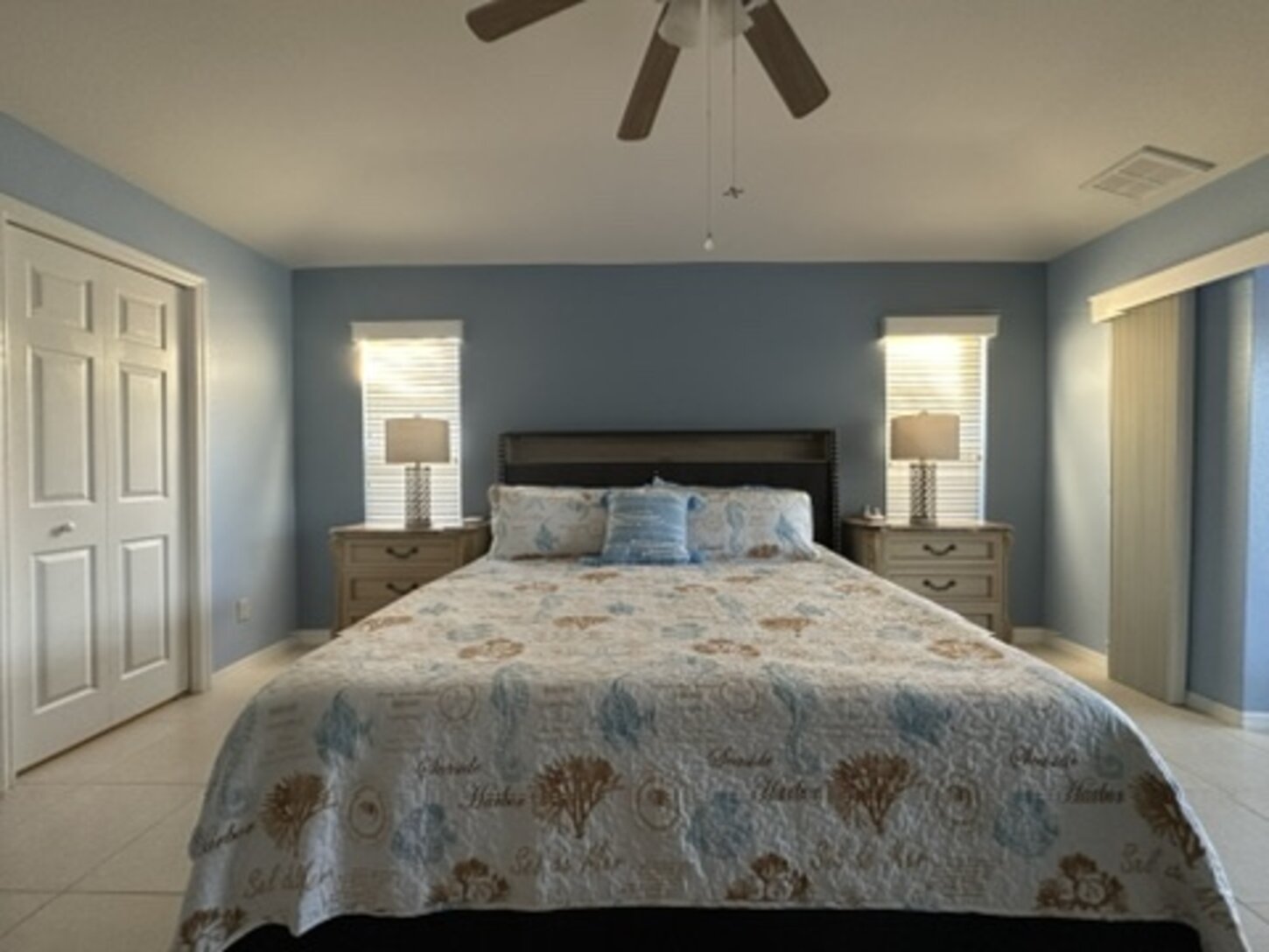 Spacious king bedroom with direct lanai access, walk-in closet, and luxurious bath with jetted tub, walk-in shower, and dual vanities.