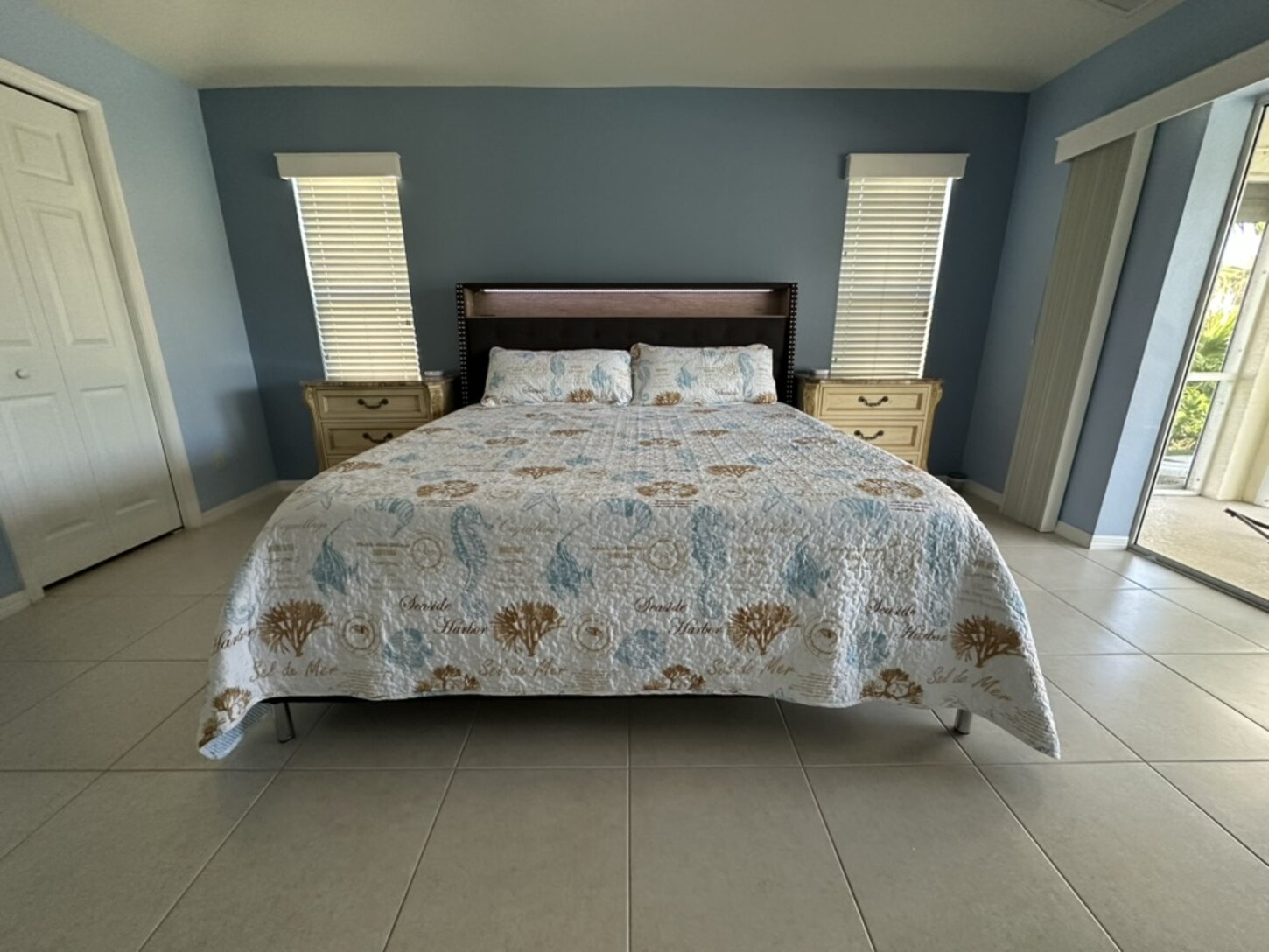 Spacious king bedroom with direct lanai access, walk-in closet, and luxurious bath with jetted tub, walk-in shower, and dual vanities.
