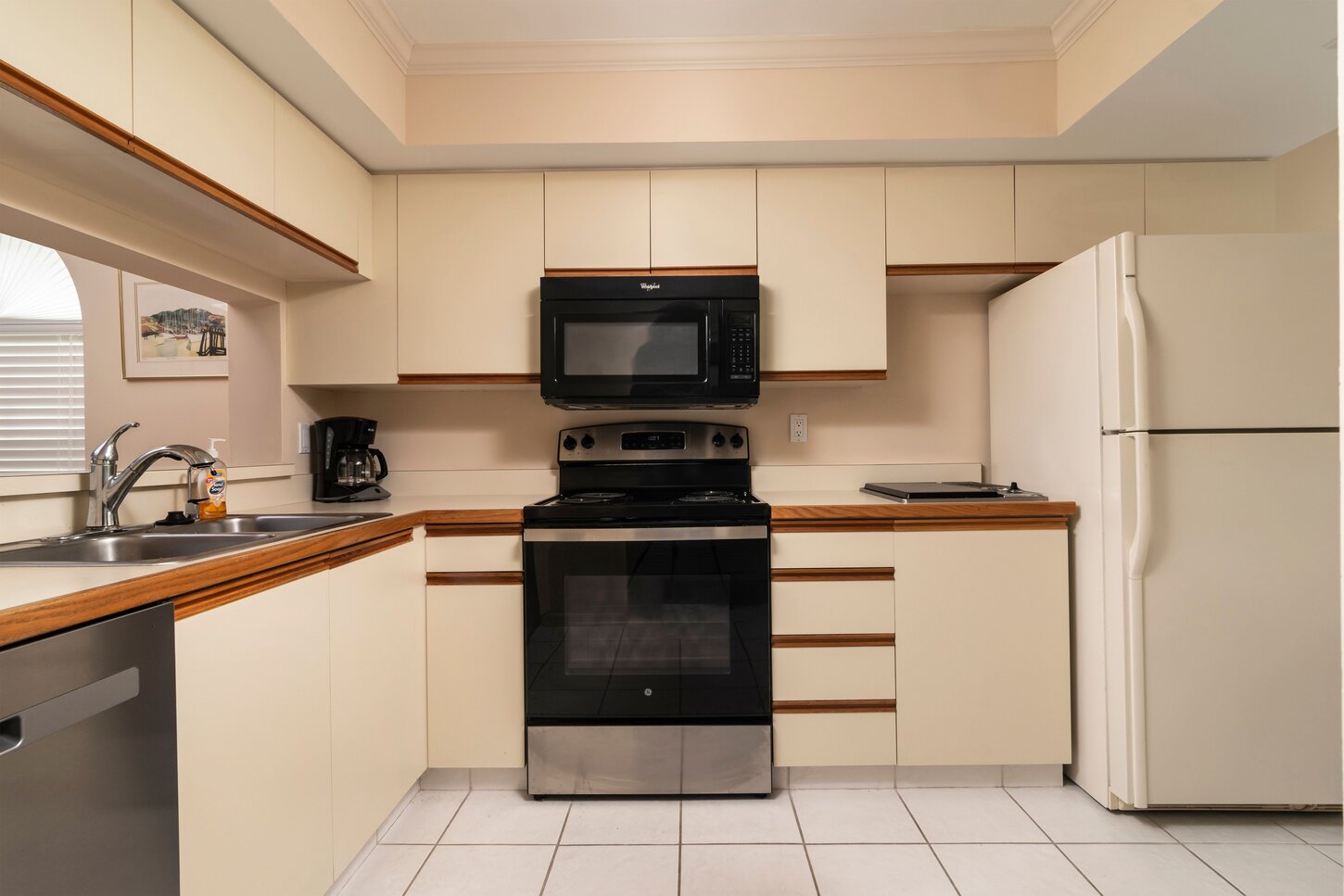 Looking in to the kitchen with hot grill,microwave, disposal, double sink a new stove, dishwasher